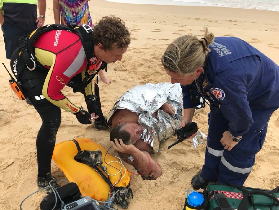 TROUBLED TIMES: Paramedics attending to a boater who spent several hours swimming after his boat capsized off Racecourse Beach on Friday. 