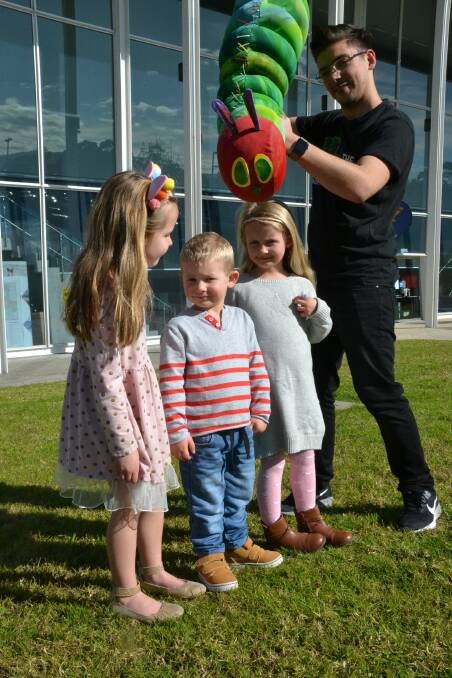 KEEN KIDS: Willow Arrold, Jai Dubois and Brooke Dubois can't wait to see the Very Hungry Caterpillar at the Shoalhaven Entertainment Centre on Thursday. Performer Scott Parker is also pictured. Picture: Rebecca Fist