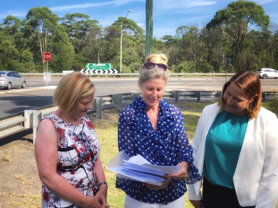 Leanne Windsor presents the petitions to South Coast Labor Candidate Annette Alldrick and Gilmore Labor Candidate Fiona Phillips at the intersection on Tuesday. Picture: Contributed