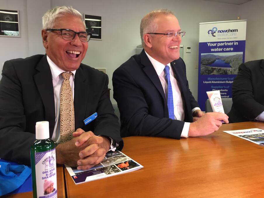 Warren Mundine hands Prime Minister Scott Morrison some locally-produced All Natural Hair Conditioner. "You could do with some of this," he said. Picture: Rebecca Fist