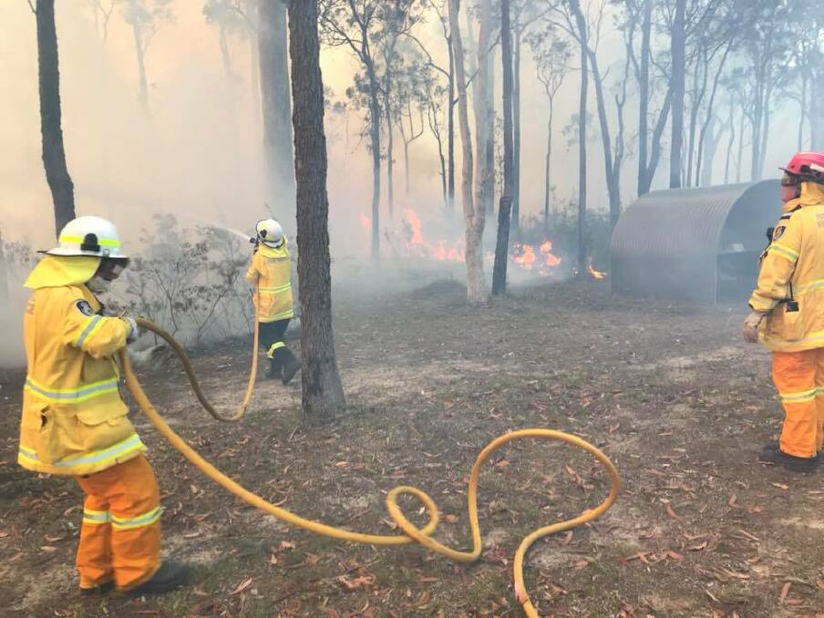 Huskisson RFS volunteers along with multiple other RFS brigades on scene undertaking property protection at a bushfire in St George’s Basin on Monday afternoon. Picture: Huskisson Volunteer RFS 