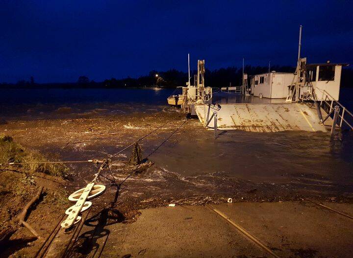 OUT OF ACTION: The Comerong Island Ferry washed up on the eastern shore Berry's Canal during early Monday morning in the Shoalhaven River flood. Image contributed.
