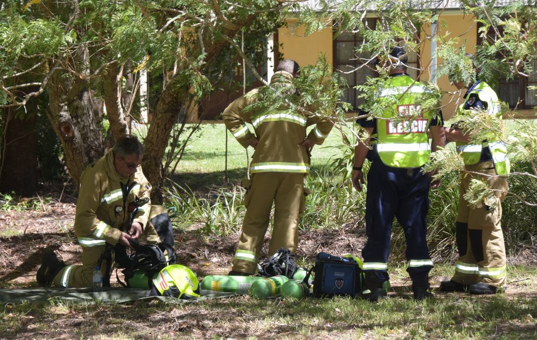 Fire and Rescue NSW crews decontaminate after extinguishing a detached garage fire in Bomaderry.