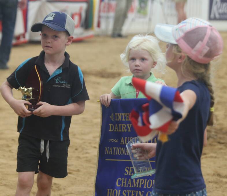 Harry. Bella and Lana Crawford with the spoils of victory after Fairvale Goldchip Melody claimed IDW grand champion Holstein.