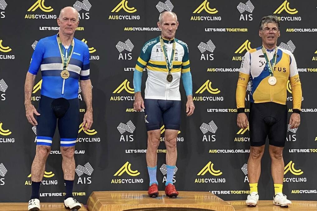 MEDAL: Adrian McMillan (right) receives one of his four bronze medals at the Australian Masters Championships.