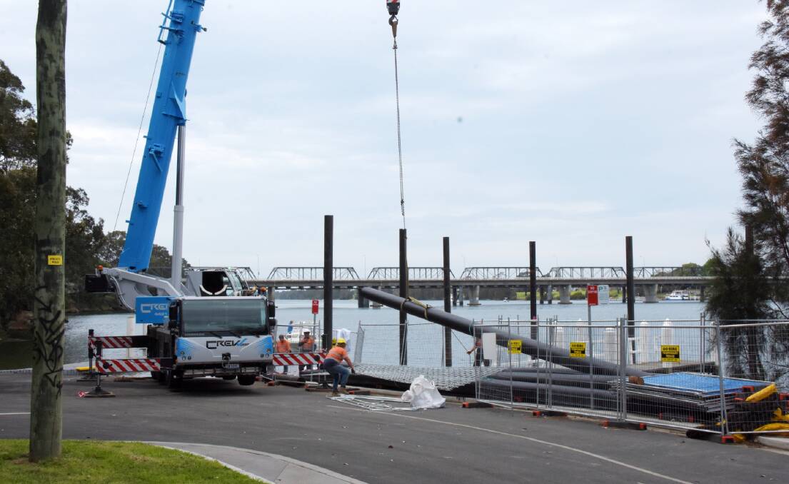 GO: Bell Rock Marine workers from Port Macquarie prepare to install a cover on one of six pylons in the Shoalhaven River for the new floating jetty at Greys Beach.