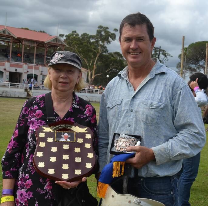 CONGRATS: Maureen Bennett presents Michael Green, the inaugural winner of the Terry Bennett Memorial Open Flag Race at this years Nowra Show with the buckle and memorial trophy.
