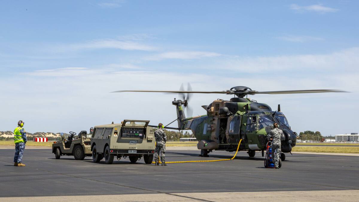 Royal Australian Navy and Royal Australian Air Force personnel prepare to launch a Royal Australian Navy MRH-90 Taipan Multi-Role Helicopter from Royal Australian Air Force Base Williamtown, Newcastle.Photo: Leo Baumgartner