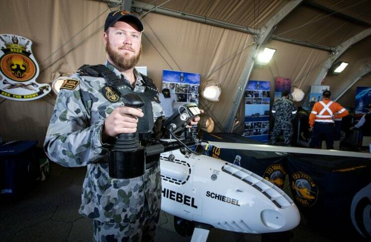  
Able Seaman Aviation Technician Avionics, Rik Murtagh, showcases the 822X Squadron S-100 Camcopter Unmanned Aircraft System at the Australian International Airshow at Avalon.  Photo:  Jessica de Rouw