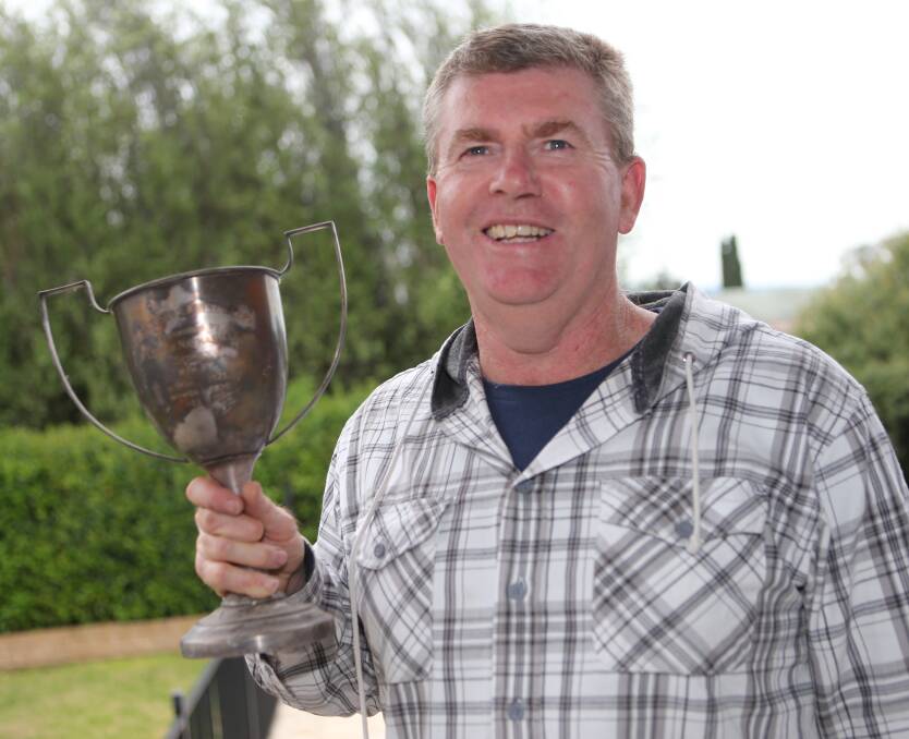
HISTORY: Chris Regan proudly shows off the Dawsons Whisky Cup won by the Pyree Rovers in 1935.
