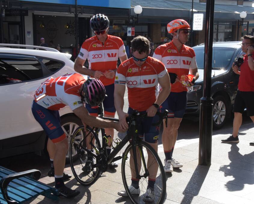 Cyclists on this year's Tour de Cure events Westpac carry out some running repairs in Nowra's Junction Street.

