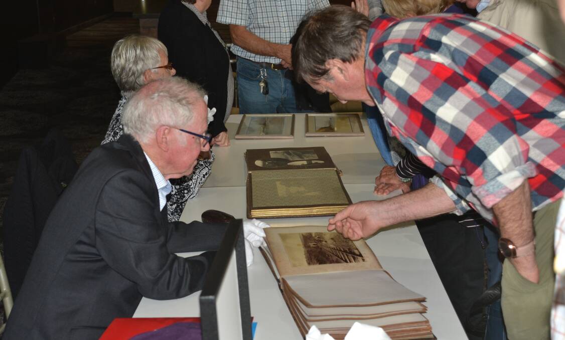ON SHOW: Shoalhaven Historical Society life member Alan Clark shows David Jones photographs of the principle construction work for the South Coast Rail Line extension from Kiama to Bomaderry.