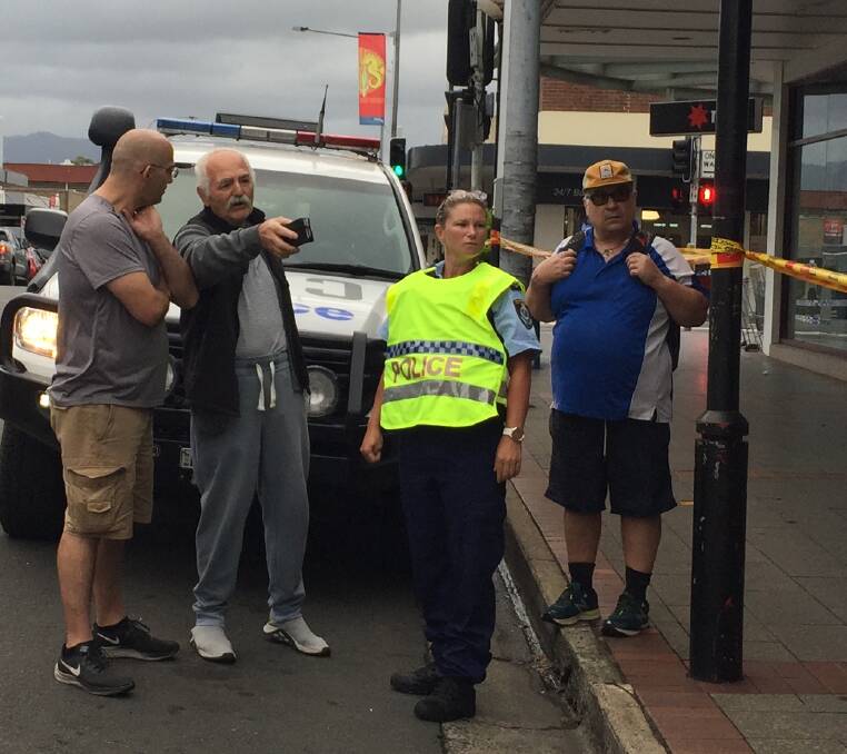 HEARTBREAKING: Nowra CBD business owner Harry Muslu (centre) talks to police after Thursday morning's fire.