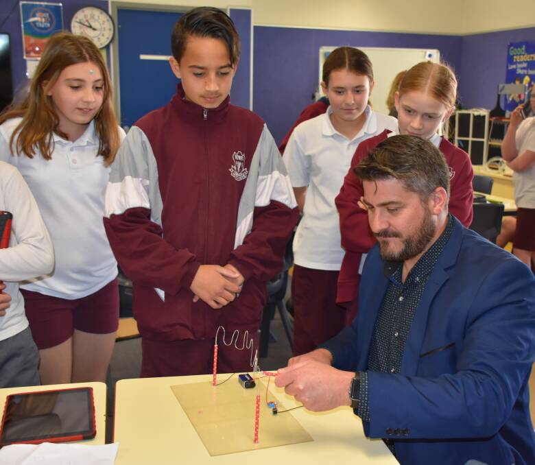 Nowra Public students watch deputy principal Brad Tate take part in one of the year 6 class experiments.