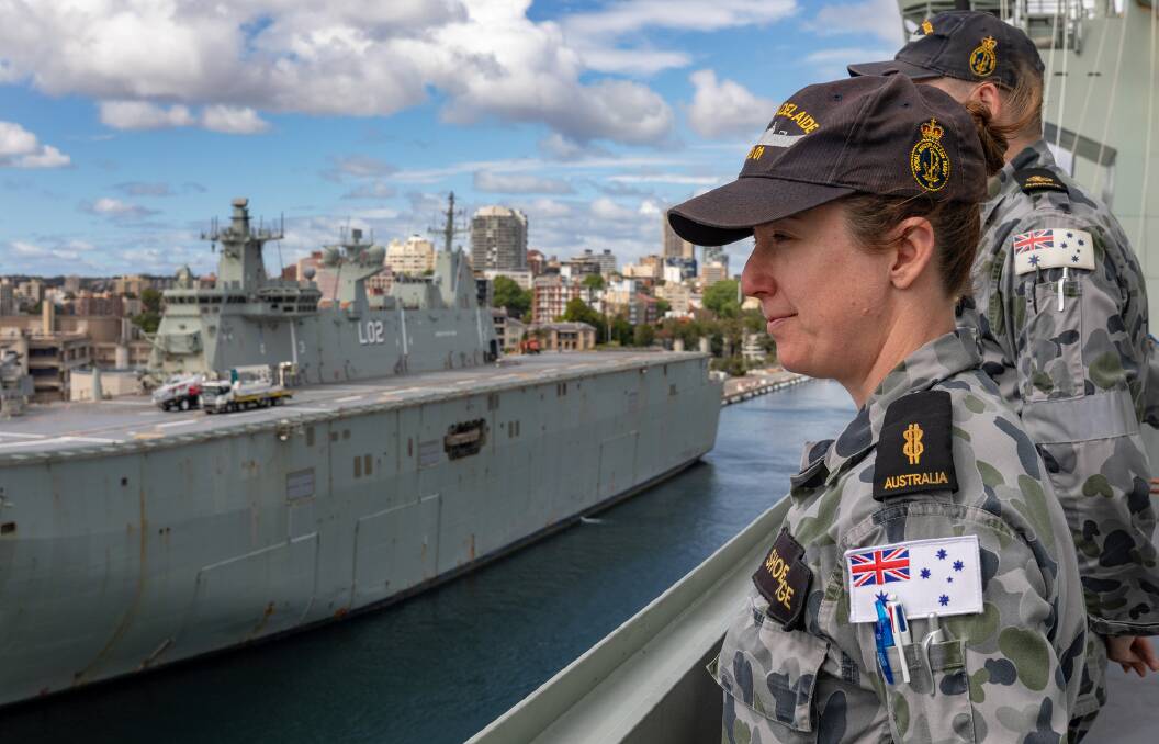 RAN Able Seaman Communication Information Systems Brooke Shoebridge stands on the upper decks of HMAS Adelaide as the ship departs Fleet Base East, Sydney, en route to take part in Operation Render Safe. Photo: Christopher Szumlanski

