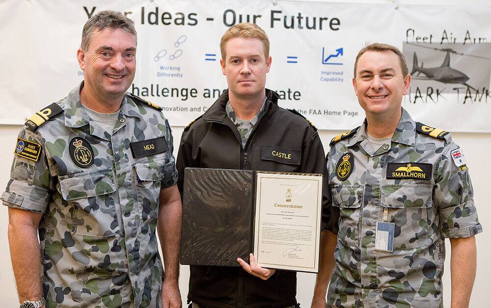 Rear Admiral Jonathan Mead (left) and Commodore Chris Smallhorn present Lieutenant Commander Craig Castle with his certificate for a navy silver level commendation at the Fleet Air Arm Shark Tank. Photo: Justin Brown