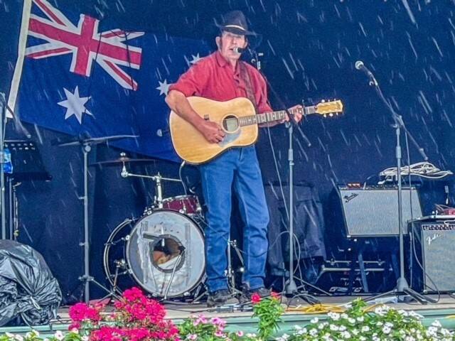 RAIN TUMBLES DOWN: Ernie Constance performs at the Terara Country Music Campout as the rain falls.
