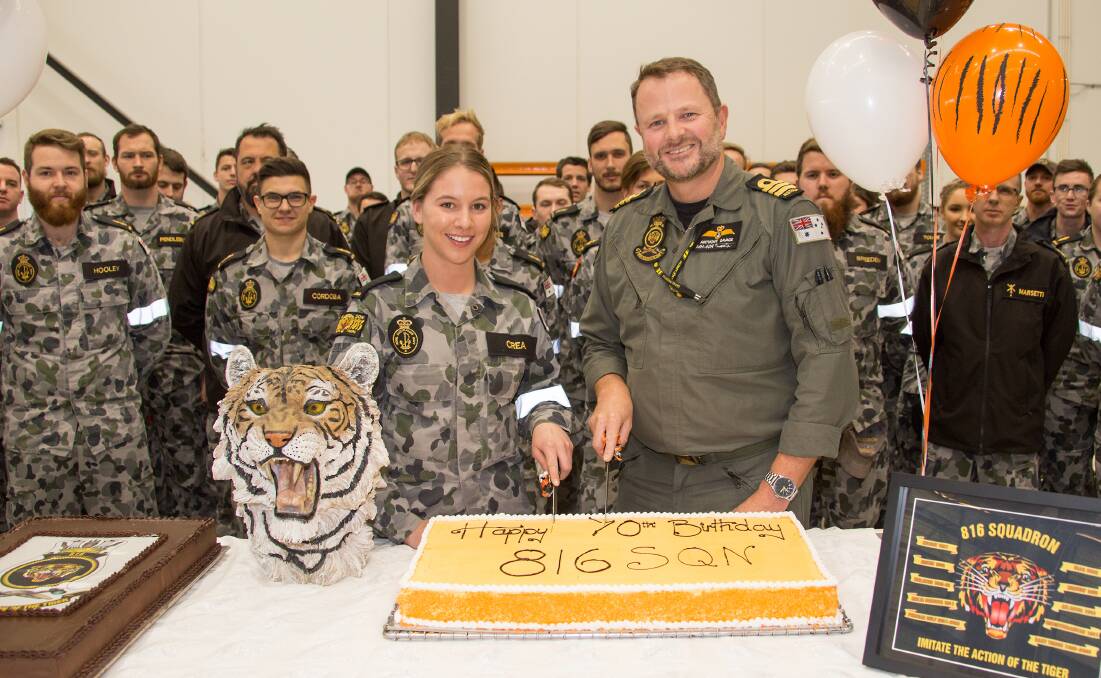 Seaman Aviation Support Jessica Crea and Commanding Officer 816 Squadron, Commander Anthony Savage cut a cake to celebrate the squadron’s 70th anniversary. Photo: Justin Brown