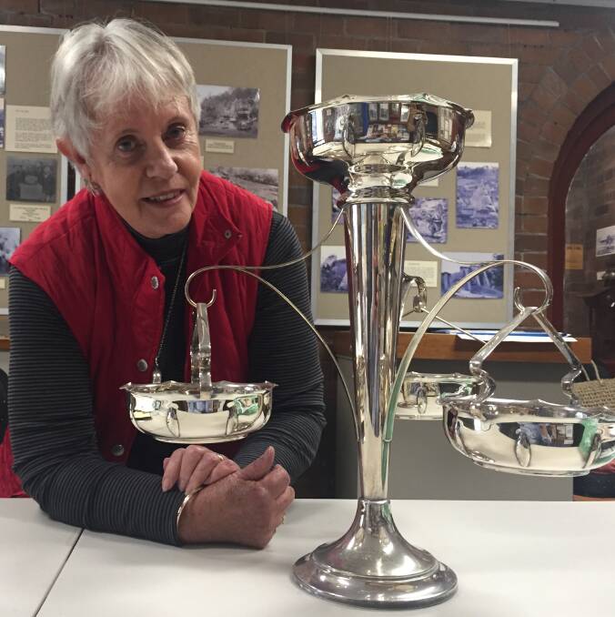 SPECTACULAR: Shoalhaven Historical Society member Gerri Walker with the beautiful Nicholson Cup won by Jim Regan in 1925 for the South Coast Skiff Championship.