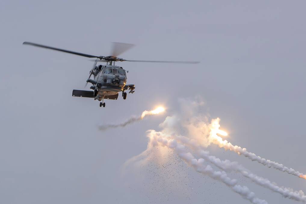 HMAS Toowoomba's embarked MH-60-R helicopter fires flares while HMAS Toowoomba conducts her patrol as part of the International Maritime Security Construct in the Middle East region. Photo: Richard Cordell 
