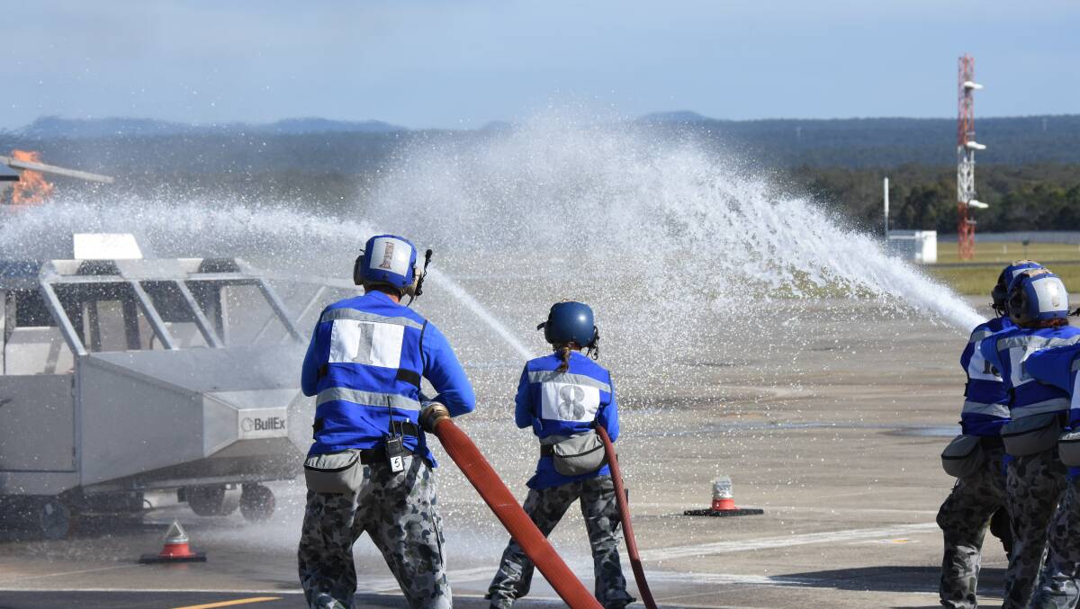 Aviation Support Category (AVN) trainees combat fire in a mock crash of a helicopter onboard a ship. Photo: Robert Crawford