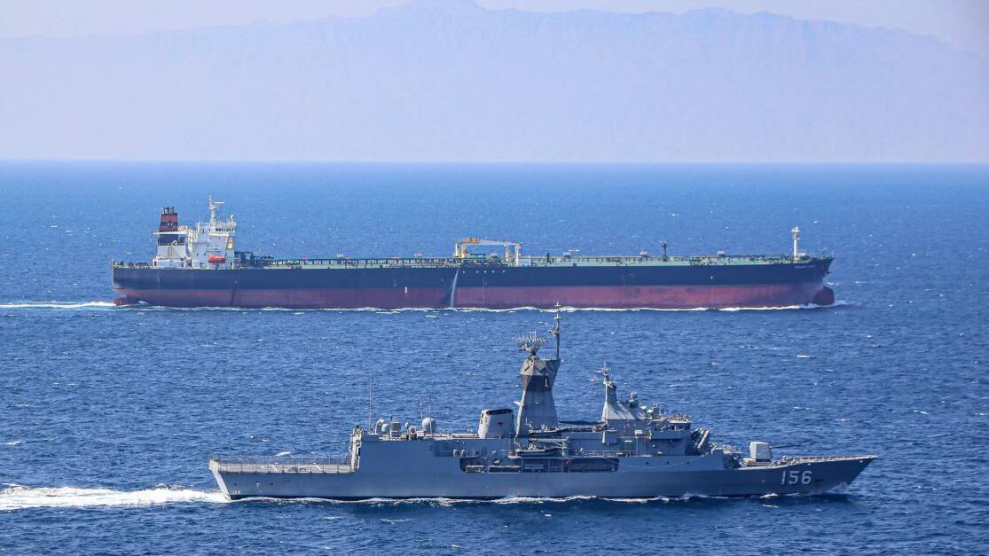 ON THE JOB: HMAS Toowoomba escorts a merchant vessel as directed by the International Maritime Security Construct while the ship is deployed to the Middle East. Photo: Sean Byrne