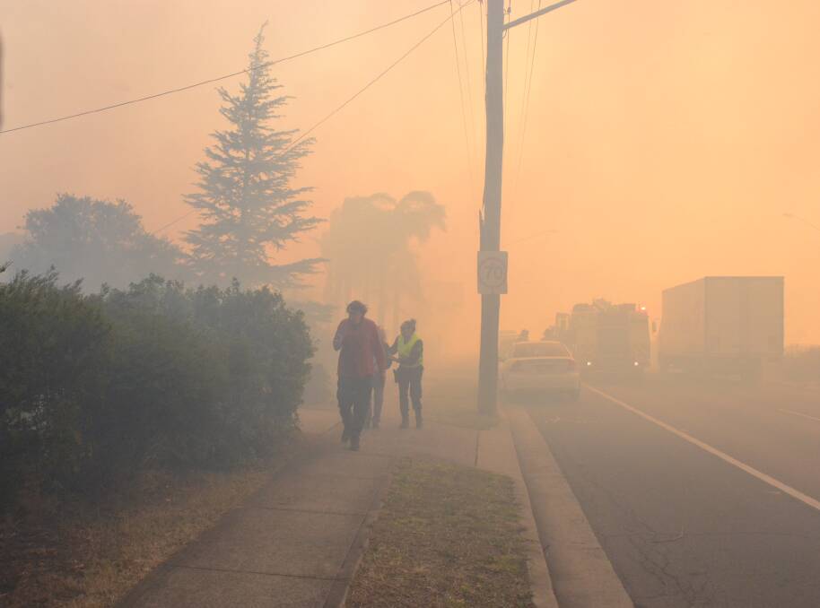 Residents escape the Bomaderry fire on Wednesday. Health authorities say symptoms can occur for several days after smoke is inhaled. Photo: Robert Crawford