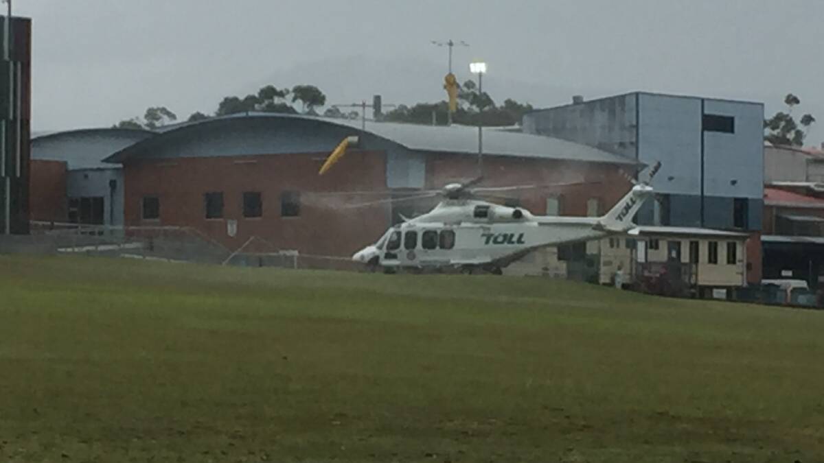 TOUCHDOWN: The Toll NSW Ambulance Rescue Helicopter lands at the Shoalhaven Hospital helipad during a passing downpour on Thursday.