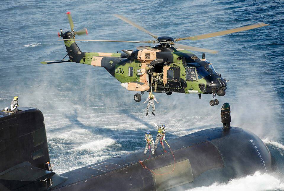 An Australian submarine conducts personnel transfers with a Navy MRH-90 Taipan helicopter. Photo: Sarah Ebsworth.