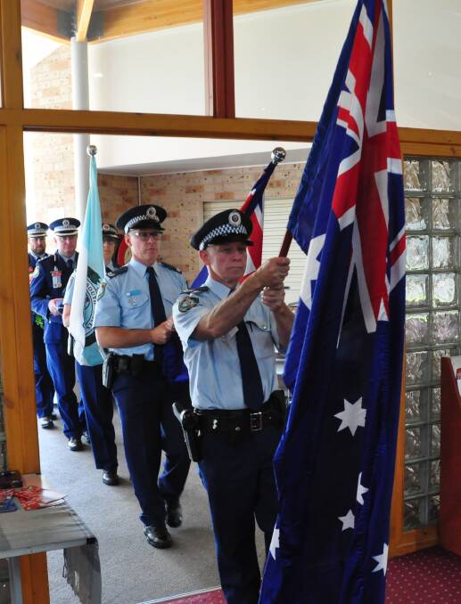  Senior Constable Mick Roberts leads the flag party into the South Coast Police District Remembrance Day.

