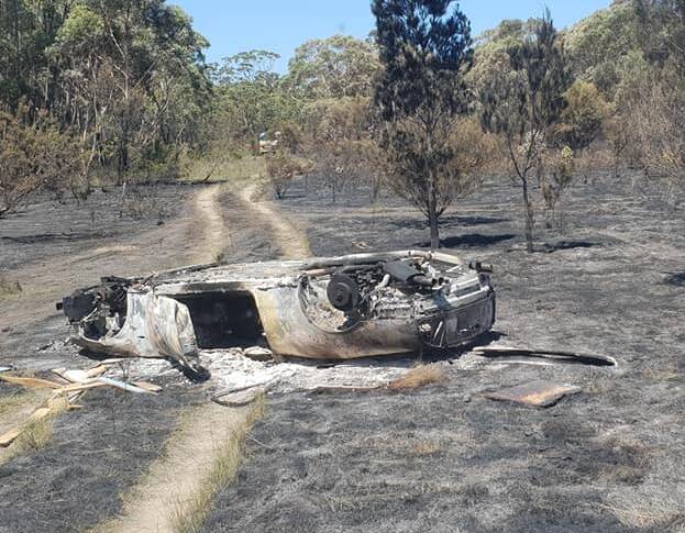TORCHED: A luxury car, later identified as a Maserati, believed to be one of the cars at the centre of the $17m cryptocurrency drug bust at Callala recently has been found burnt out in bush west of Tomerong. Photo: Tomerong RFS