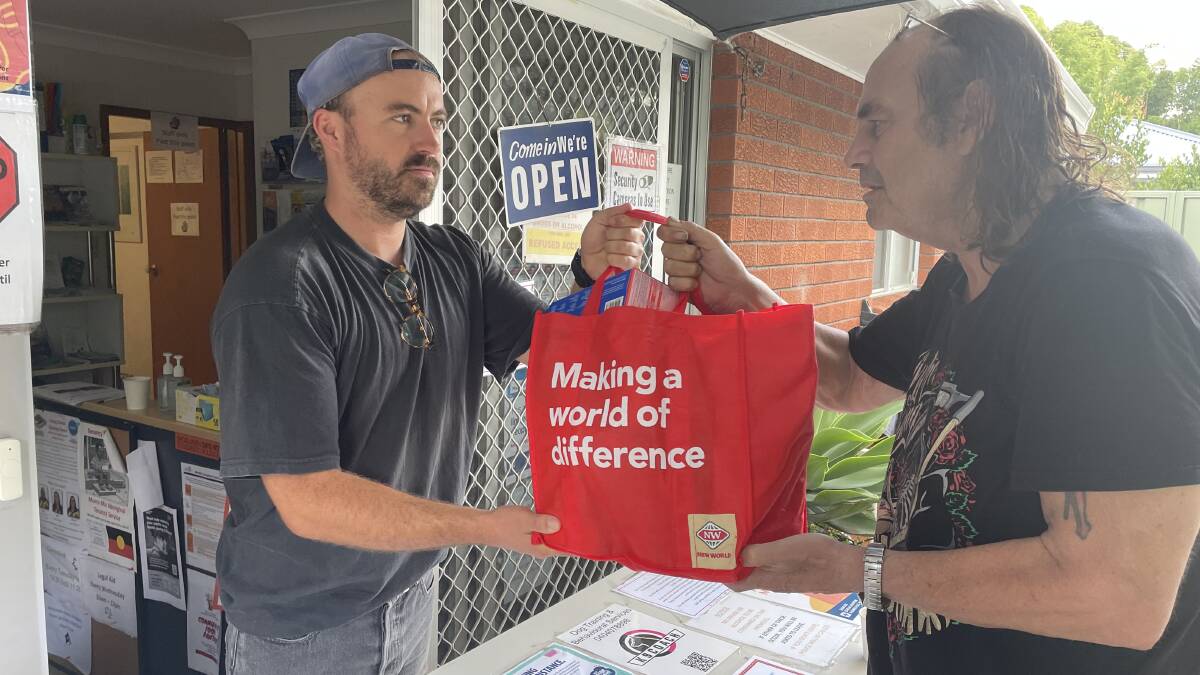 HELP: Shoalhaven Homeless Hub case worker Joey Winkler hands over a bag of food and other essentials to local man Ken Weir, who is living out of his car and a tent. Image: Robert Crawford