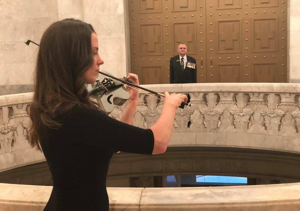 Violinist Rachel Bostock plays a stirring rendition of The Last Post with Keith Payne VC at the Anzac Memorial in Hyde Park, Sydney.