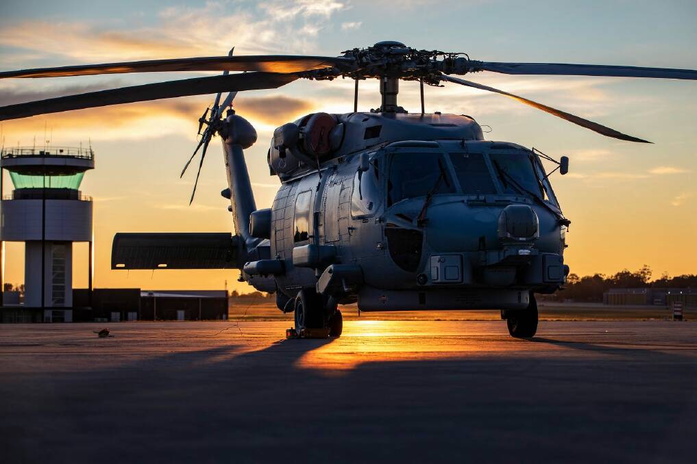 TOP BIRD: MH-60R Romeo helicopter from 816 Squadron is silhouetted against the morning sun on the flight line at HMAS Albatross. Photo: Cameron Martin