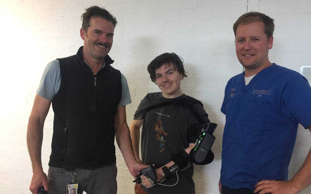 NEW ADVENTURE: Caseworker/physiotherapist Damien Barratt (left) and Jens Baufeldt, of X-tremity Prosthetics and Orthotics in Nowra with Khy Antoniazzo and his new MyoPro powered arm.