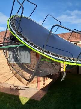 DANGER: Above and below - A number of trampolines have become potentially dangerous weapons after being picked up in the strong winds. Local residents are being asked to ensure their trampolines are properly secured. Images: Nowra SES Unit 