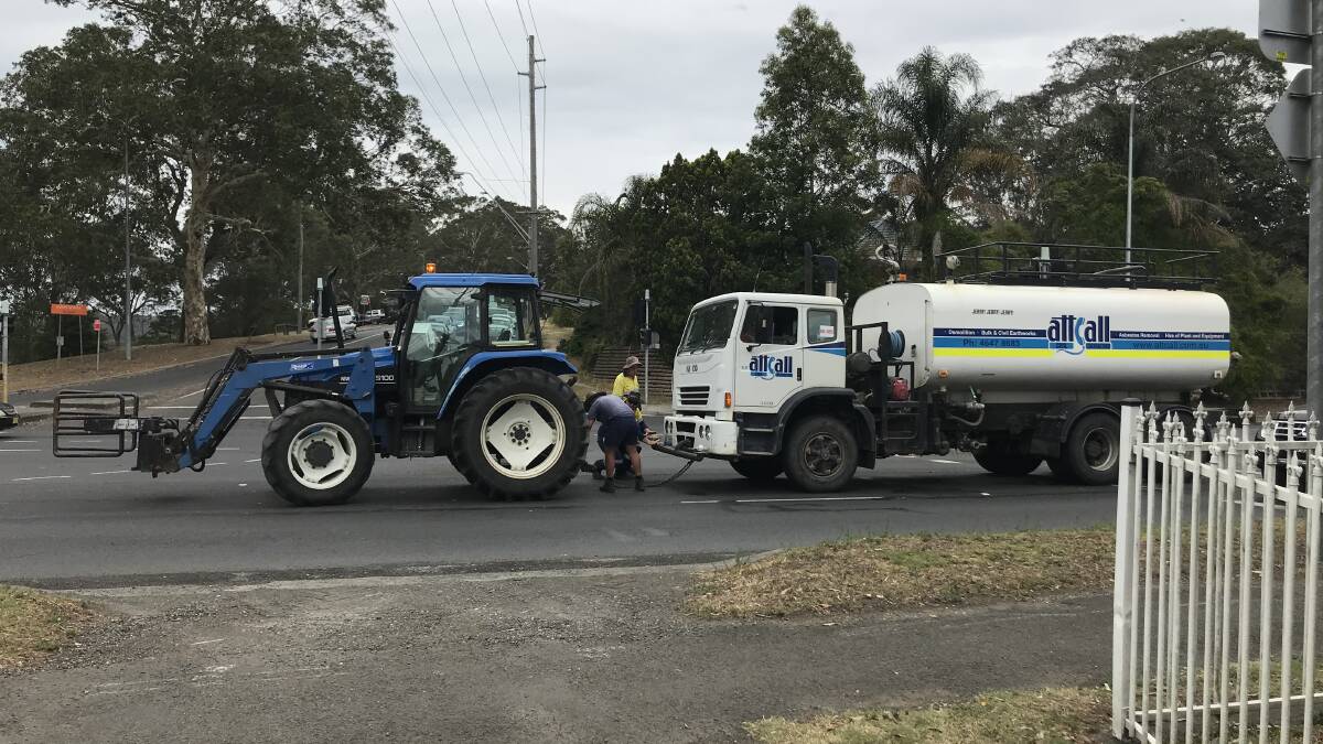 Local farmer John Bryce hooks his tractor onto the broken down truck before towing it off the Princes Highway on Tuesday morning. Photo: Supplied