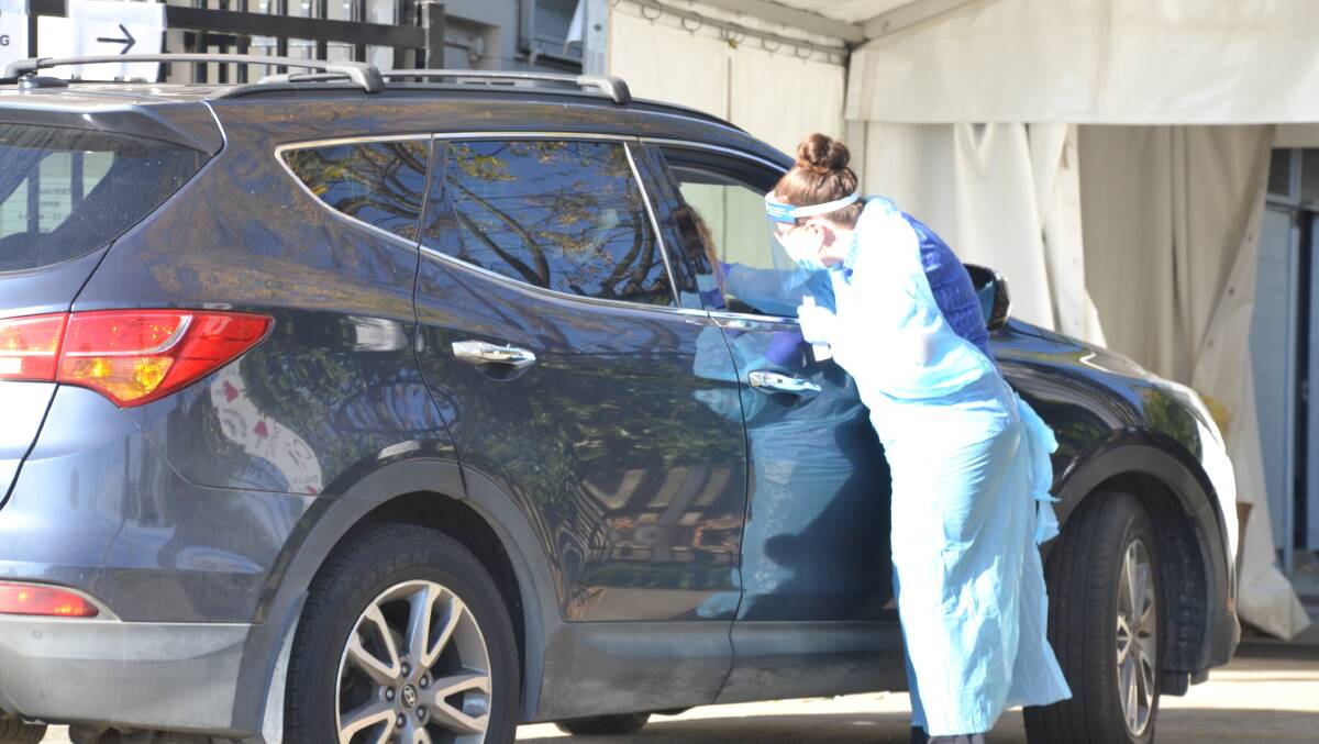 TEST: A Southern IML Pathology staff member undertakes a COVID test at Nowra's drive-through clinic.