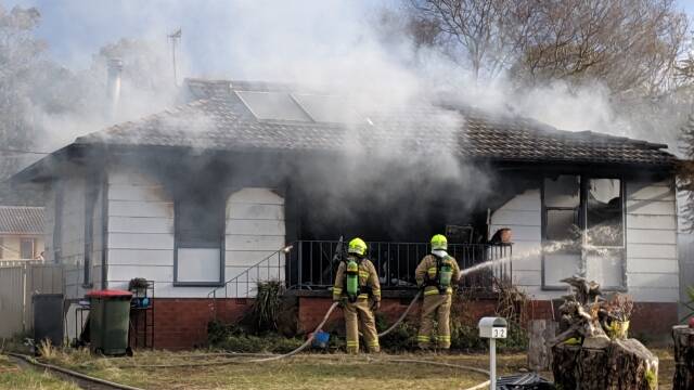 OUT: Fire and Rescue NSW crew extinguish the North Nowra house fire. Photo: Stuart Thomson