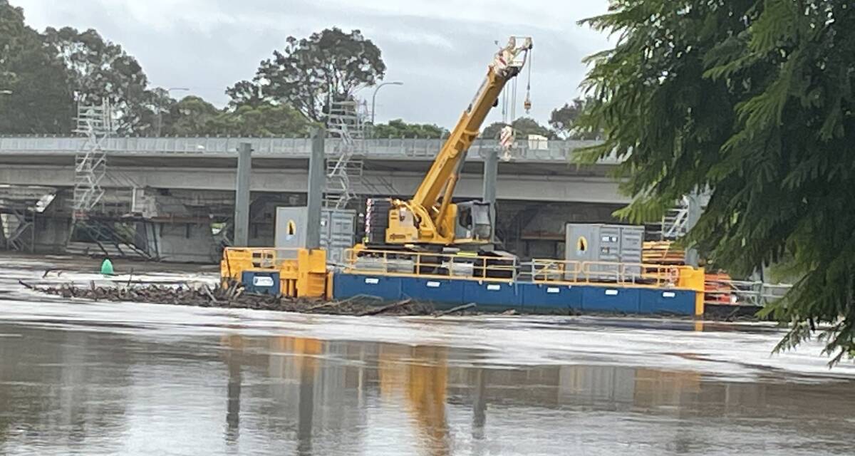 FLOOD IMPACT: The flooded Shoalhaven River caused one of the work barge's anchors on the new $342 million Nowra bridge project to move. Look at the debris collected on the front of the barge.