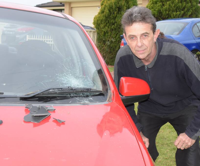 Crime scene: Nowra man Brad Reeves inspects the damage to one of his cars in Wednesday night's pipe bomb attack, which police say was "targeted".