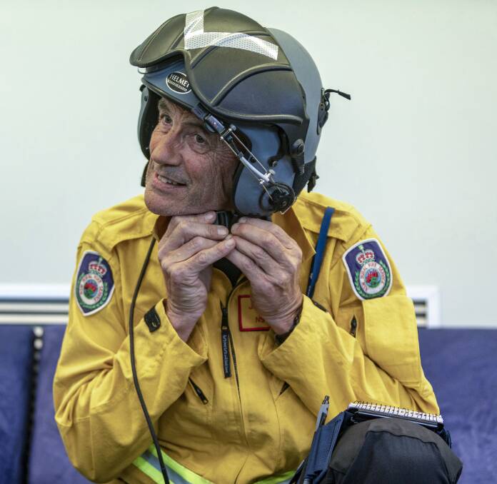 RFS volunteer Jeff Hodder dons a helmet prior to leaving Royal Australian Air Force Base Williamtown, Newcastle, to support the firefighting efforts. Photo: Leo Baumgartner