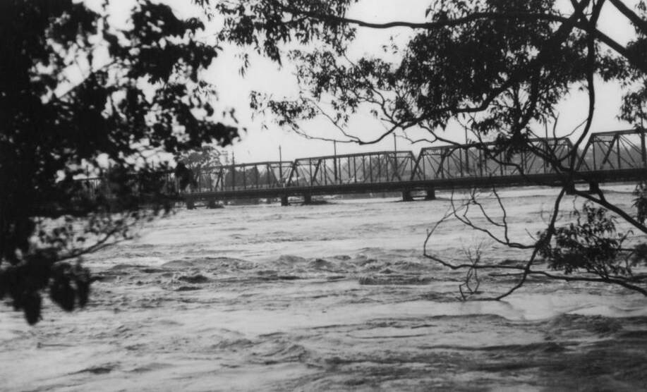 The Nowra bridge has survived numerous floods in his 137-year history. This one is in 1974 from Bryce's farm on the northern side of the river looking south west. Photo: Shoalhaven Historical Society