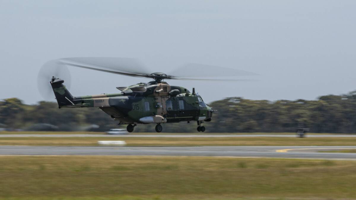 A Royal Australian Navy MRH-90 Taipan Multi-Role Helicopter takes off from Royal Australian Air Force Base Williamtown, Newcastle, to support the firefighting efforts. Photo: Leo Baumgartner
