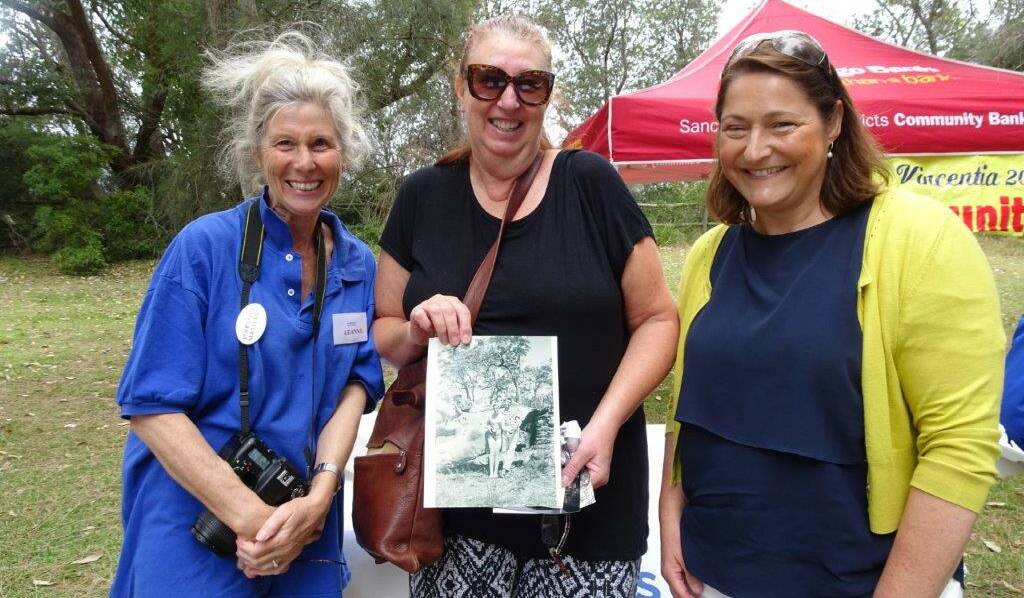 Gilmore MP Fiona Phillips with leader of the Vincentia Matters' history group Leanne Windsor and Tracey Banfield showing a photo taken 60 years ago in Waldegrave Crescent, Vincentia.