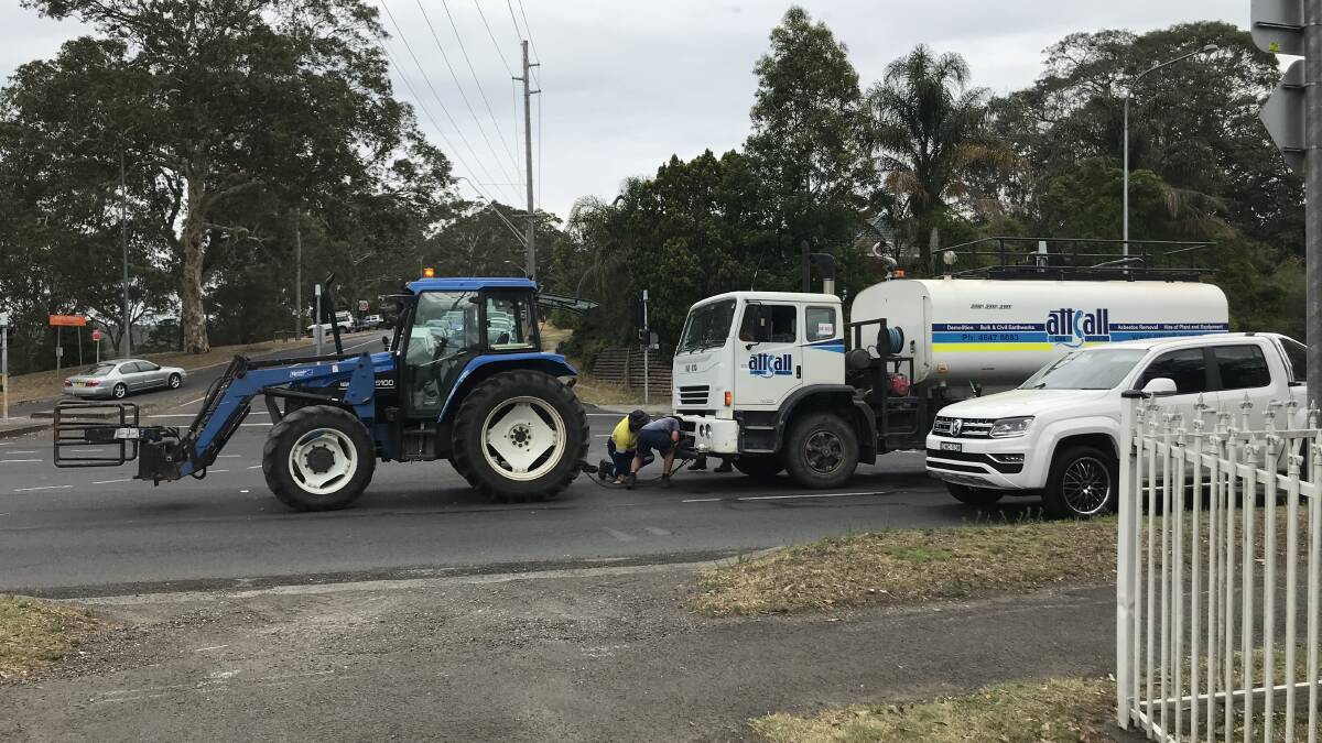 Local farmer John Bryce hooks his tractor onto the broken down truck before towing it off the Princes Highway on Tuesday morning. Photo: Supplied