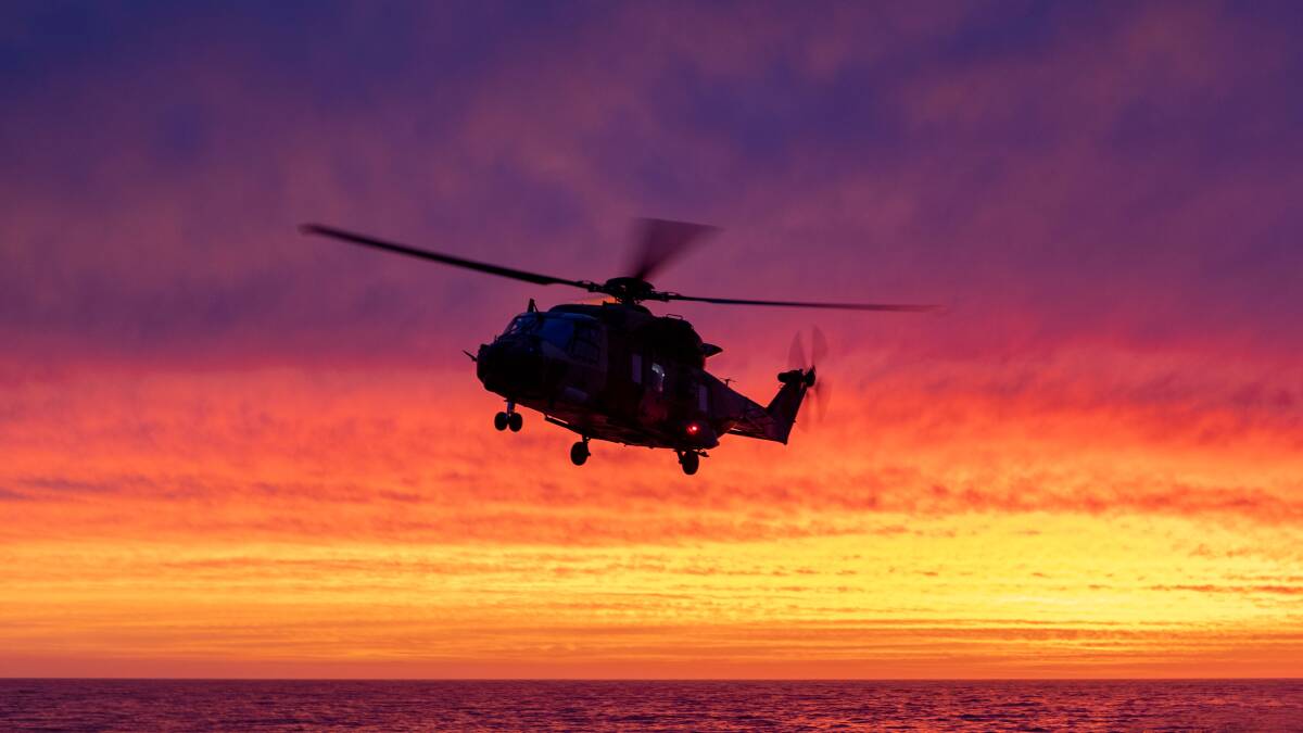BEAUTIFUL: HMAS Choules' MRH-90 Maritime Support Helicopter makes a final approach to land at sunset during the ship's fire mission. Photo: Shane Cameron