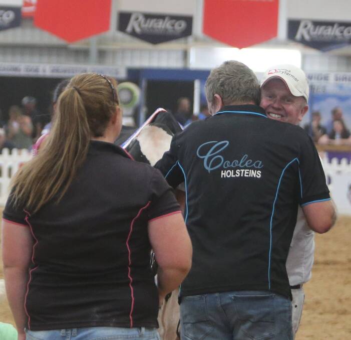 Andrew and Darren Crawford celebrate winning the grand champion Holstein with Fairvale Goldchip Melody.