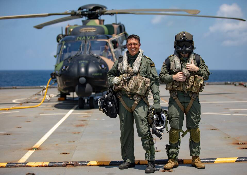 Royal Australian Navy Aircrewmen Petty Officer David Vowell (left) and Leading Seaman Brendan Menz (right) in front of the MRH-90 Multi Role Helicopter embarked aboard HMAS Choules as the ship sails to take part in the commemoration of the Australian-led International Force East Timor (INTERFET). Photo: Christopher Szumlanski