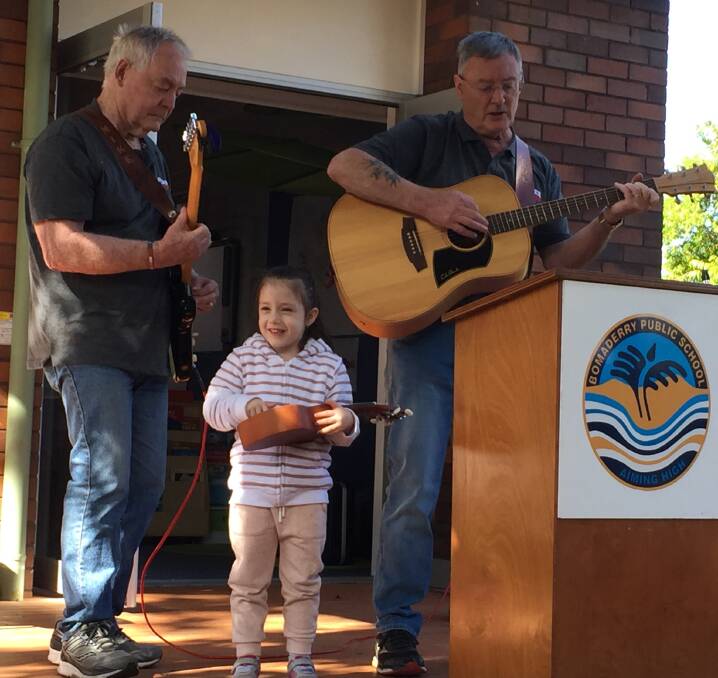 STAR: Five-year-old Alexis Peters joins Soldier On Music Group members Mike Hogan and Col Greef on stage during their performance.